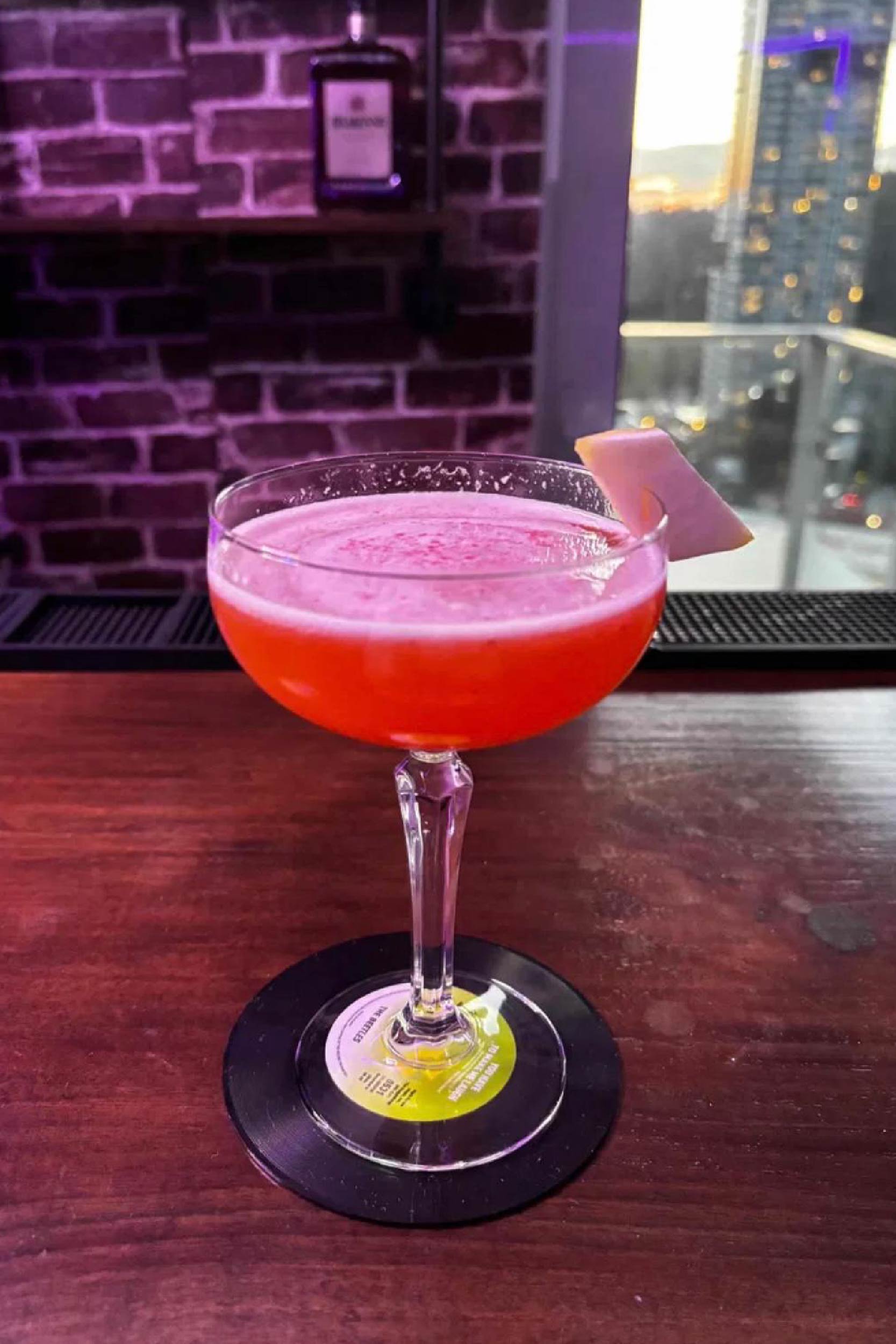 Nocturne — deep teal coupes with sugar rim and blueberry lemon garnish